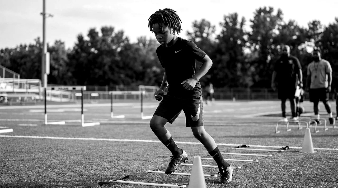 Young athletes training through an agility ladder